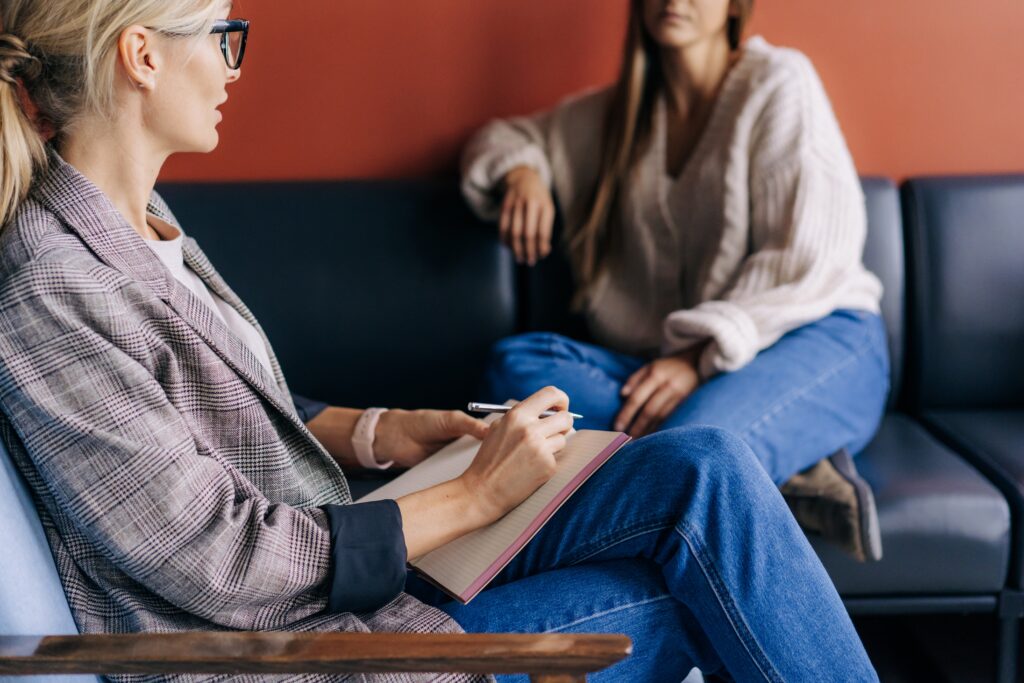 Woman getting psychotherapy sitting on the couch across from her therapist