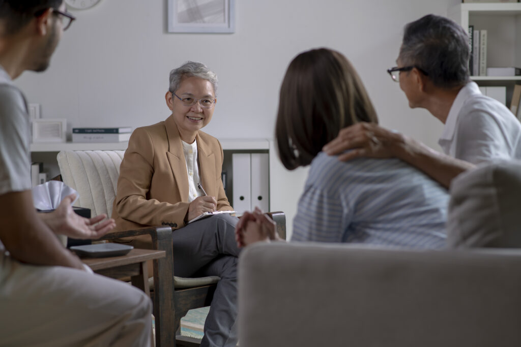 Therapist, psychologist talking and counselling to people in group therapy.